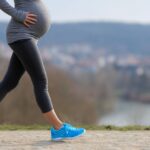 Trudnica šeta na otvorenom i drži ruku na stomaku