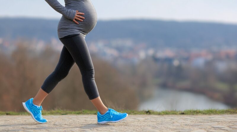 Trudnica šeta na otvorenom i drži ruku na stomaku