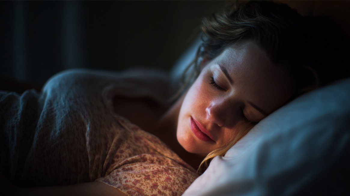 Trudnica mirno spava na boku u zamračenoj sobi